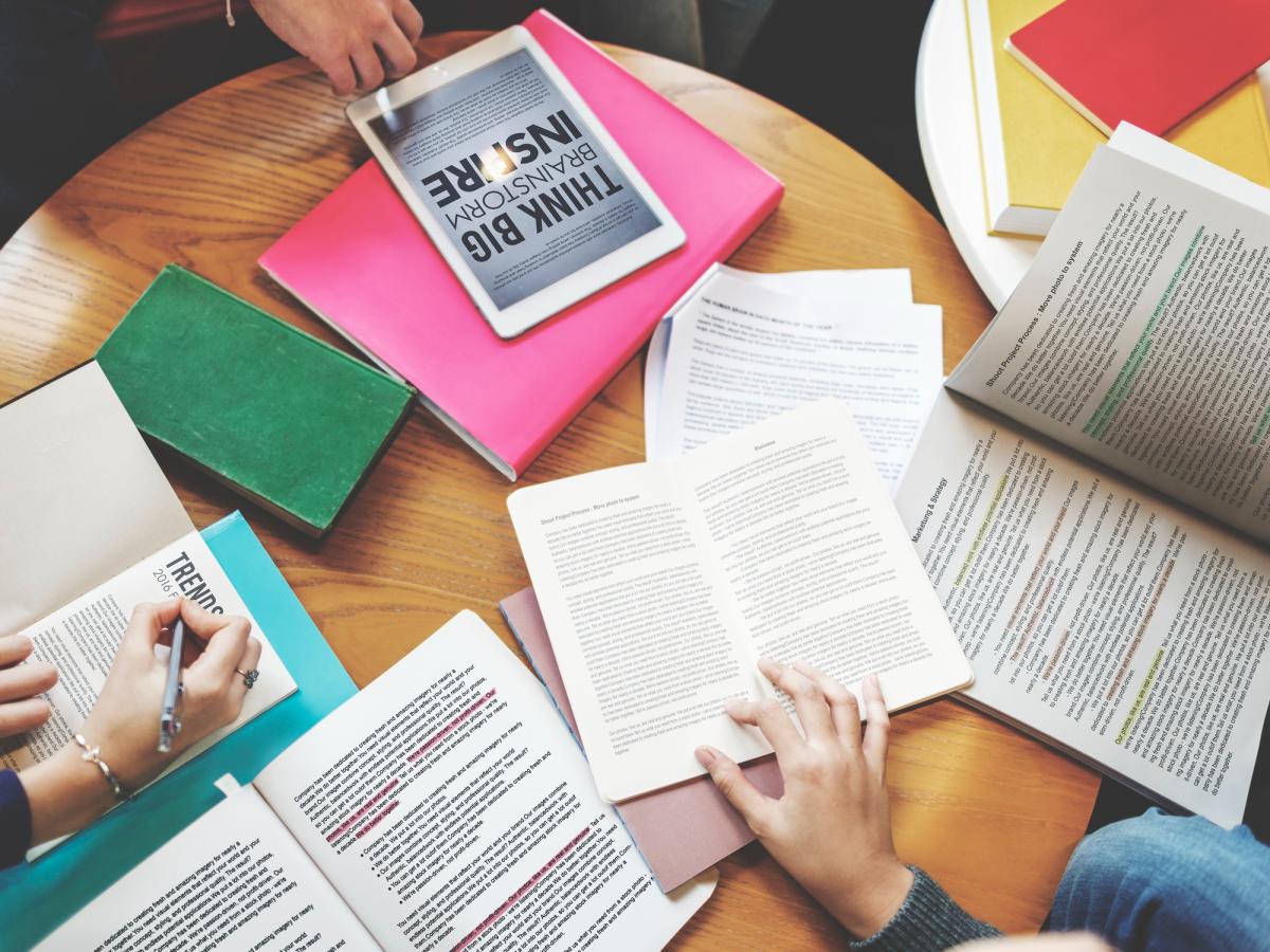 Shows a group of students reading and researching for class