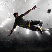 soccer player kicking the ball in mid-air